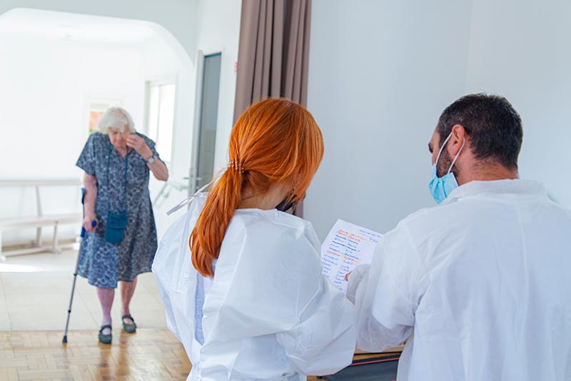 11Photo d'une femme âgée avançant vers un médecin une infirmière à la maison de retraite La Constance à Marseille. Photo © Aurélien Meimaris