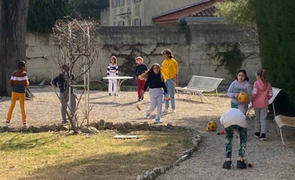 11Photo d'enfants jouant au ballon avec des seniors dans le jardin de La Constance