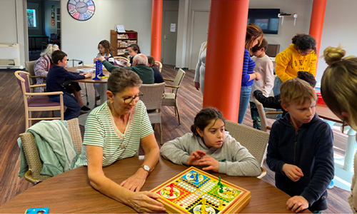 Photo d'enfants et personnes âgées jouant à  un jeu de société à La Constance, résidence seniors Marseille 