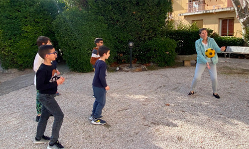 Photo d'enfants jouant au ballon avec des seniors dans le jardin de La Constance