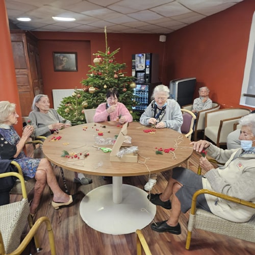 La Constance - Résidence seniors à Marseille - Photo de résidents autour d'une table confectionnant des décorations pour fêter Noël en maison de retraite