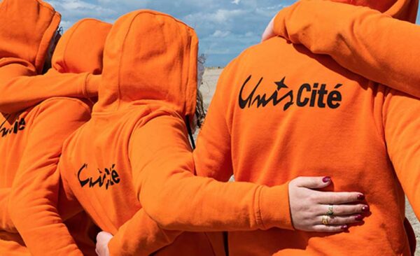 11©Photo d'Unis-Cité : jeunes en service civique de dos en sweat orange. Photo pour illustrer l'article "service civique en maison de retraite" à La Constance, résidence seniors à Marseille